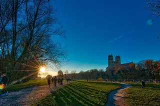 Herbstspaziergang an der Isar in München, im Hintergrund die Kirche St. Maximilian